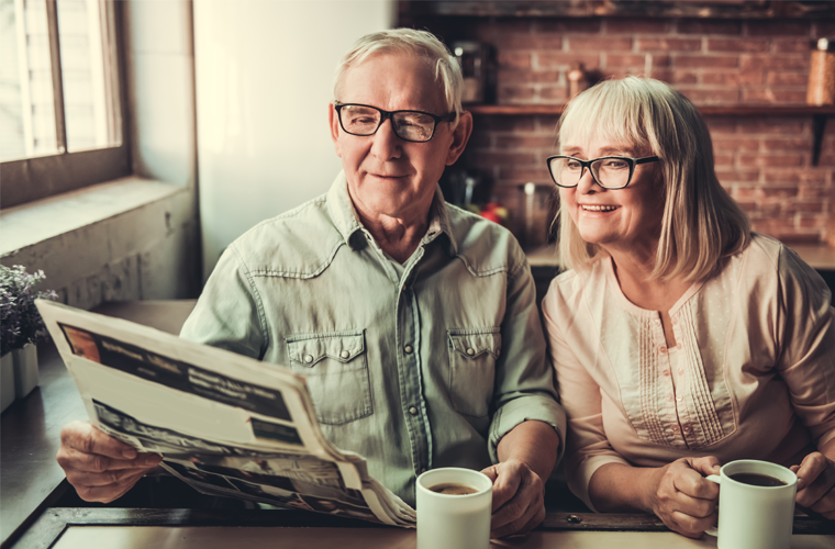Couple in their retirement reading newspaper